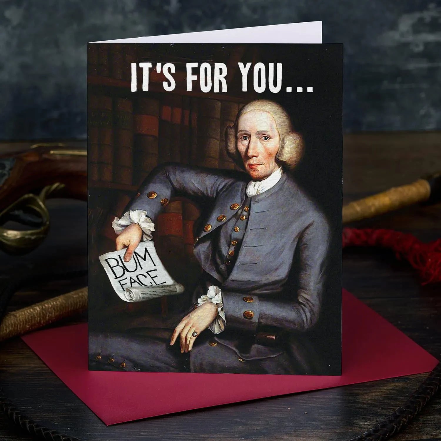 Card with a historical figure holding a sign saying 'Bum Face' on a dark background