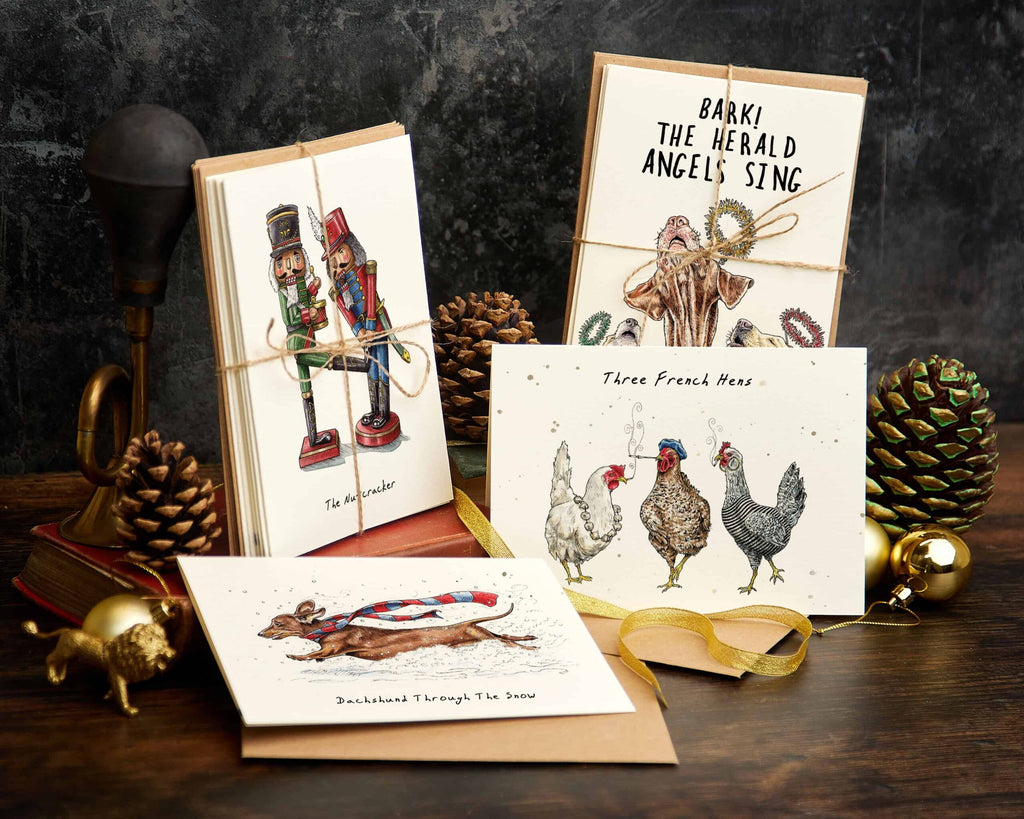 Collection of Christmas-themed greeting cards on a wooden surface with decorative elements.