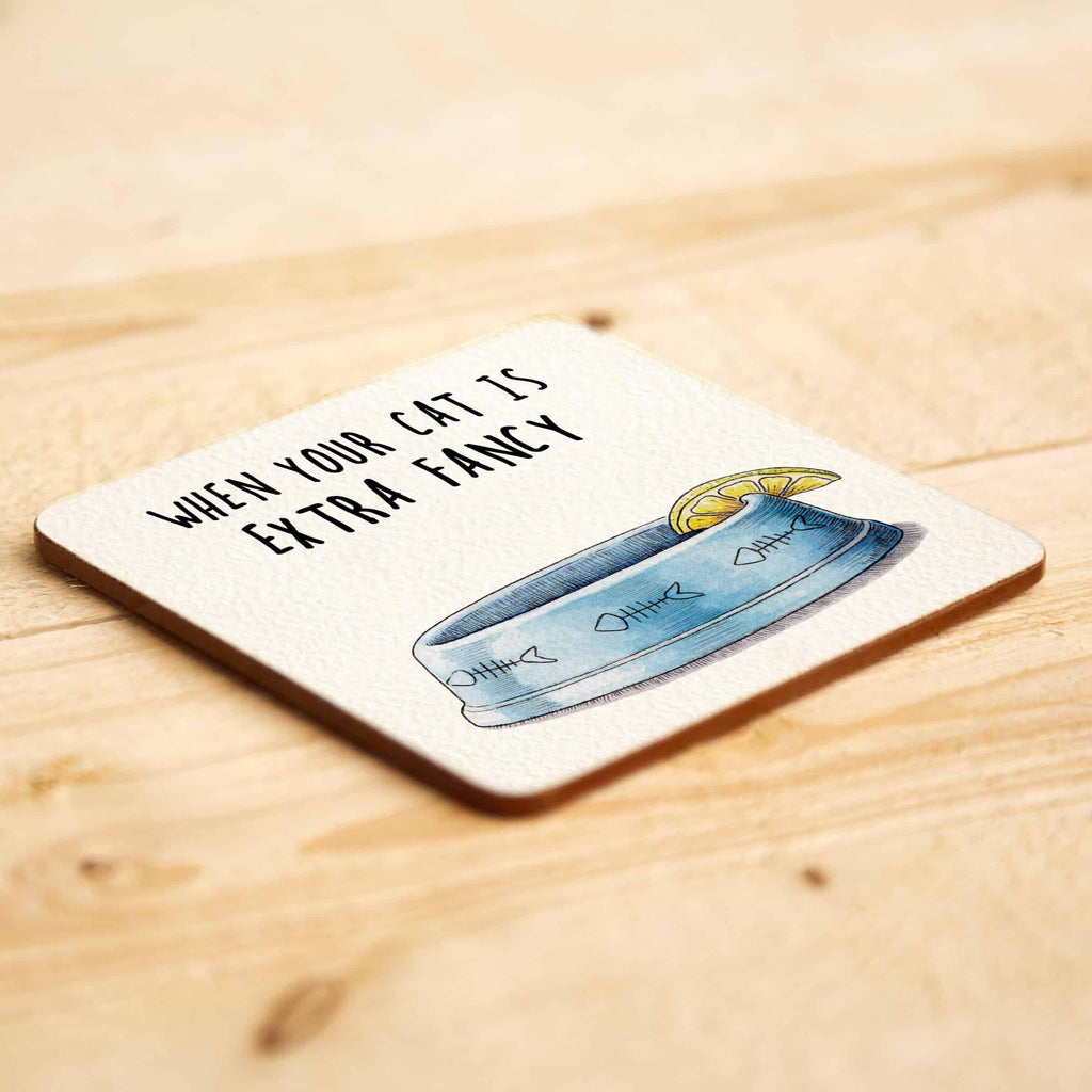 Coaster with cat bowl illustration and text on a wooden surface