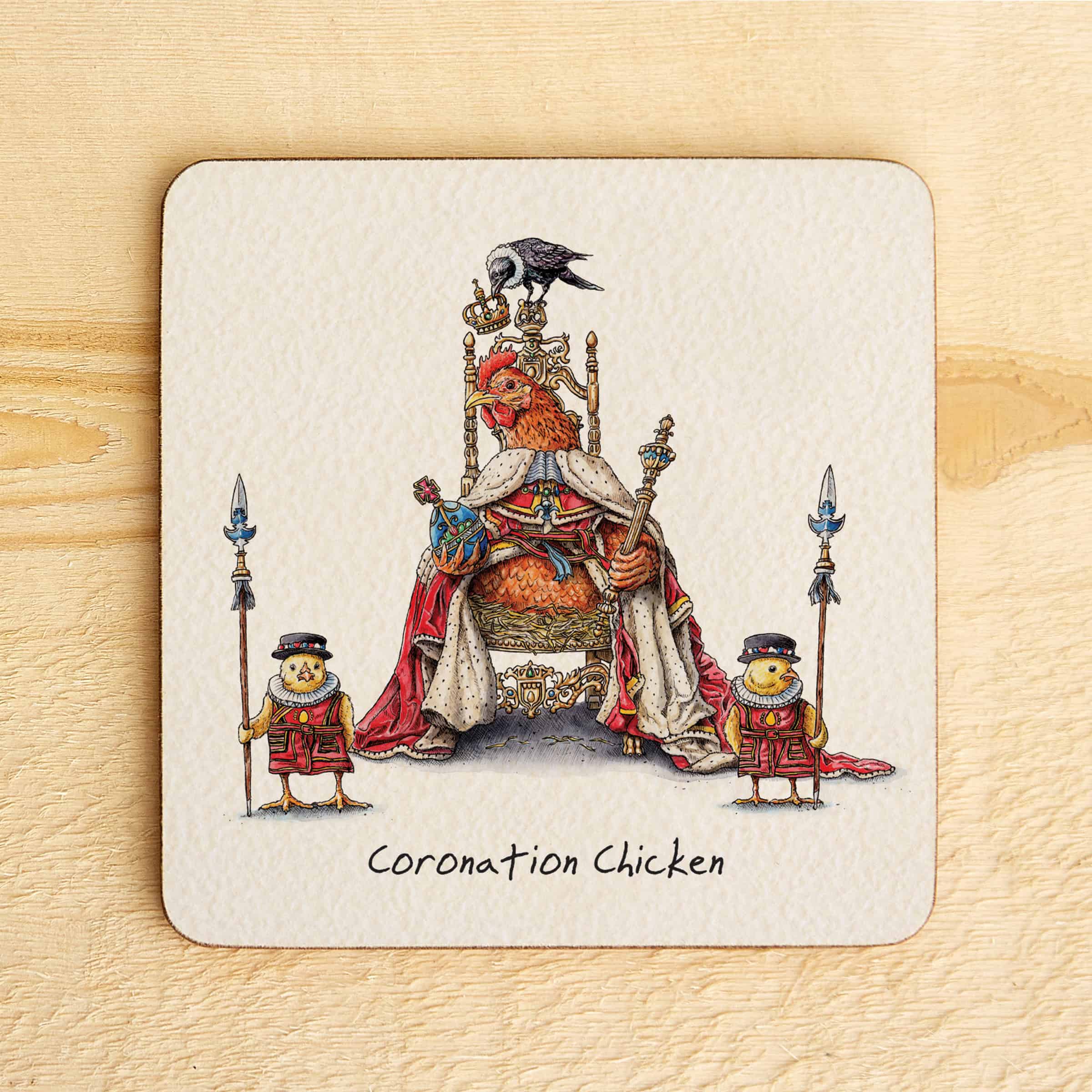 Coaster with illustration of a chicken on a throne, surrounded by two smaller chickens, on a wooden surface.