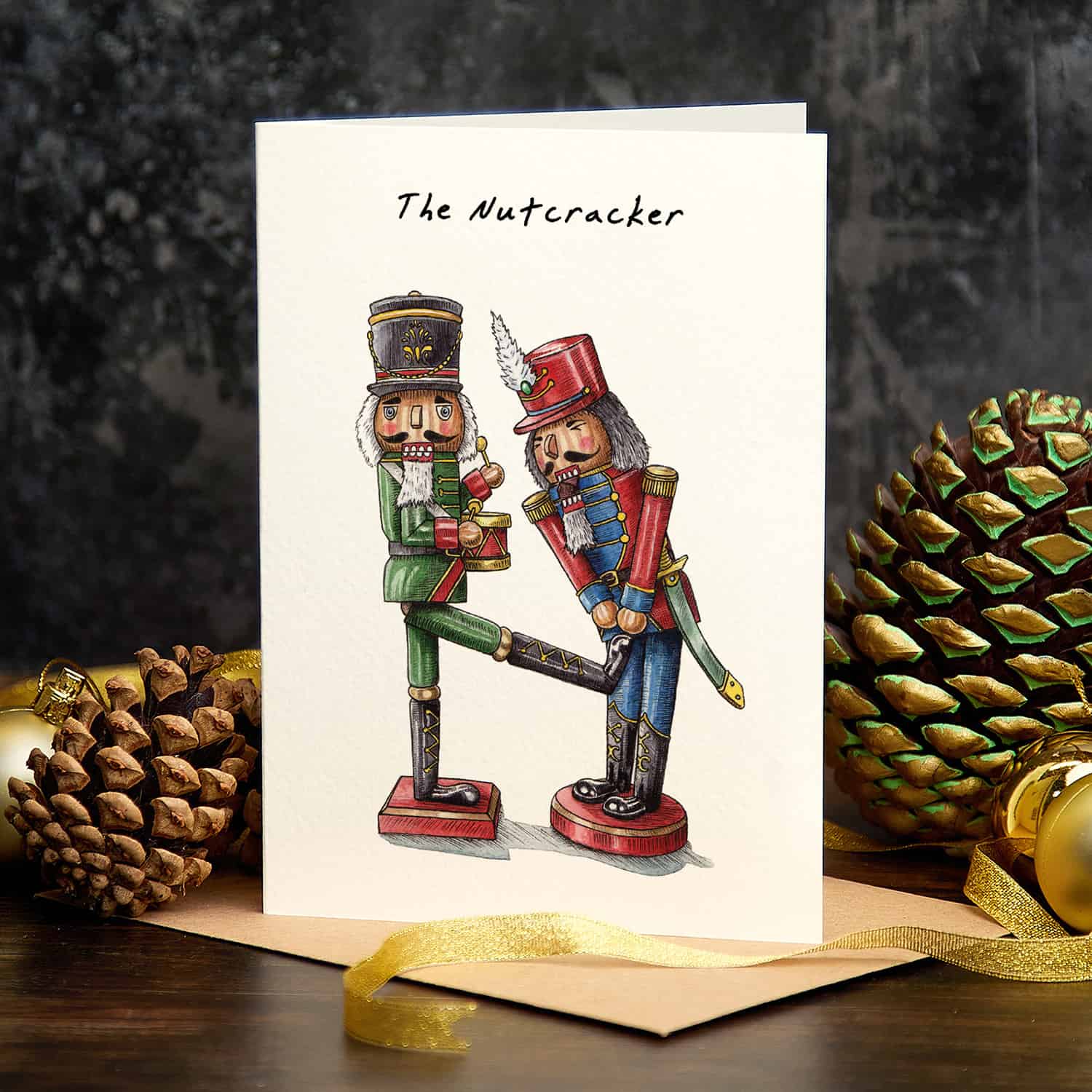 Greeting card with 'The Nutcracker' design featuring two nutcrackers and pine cones on a dark background.