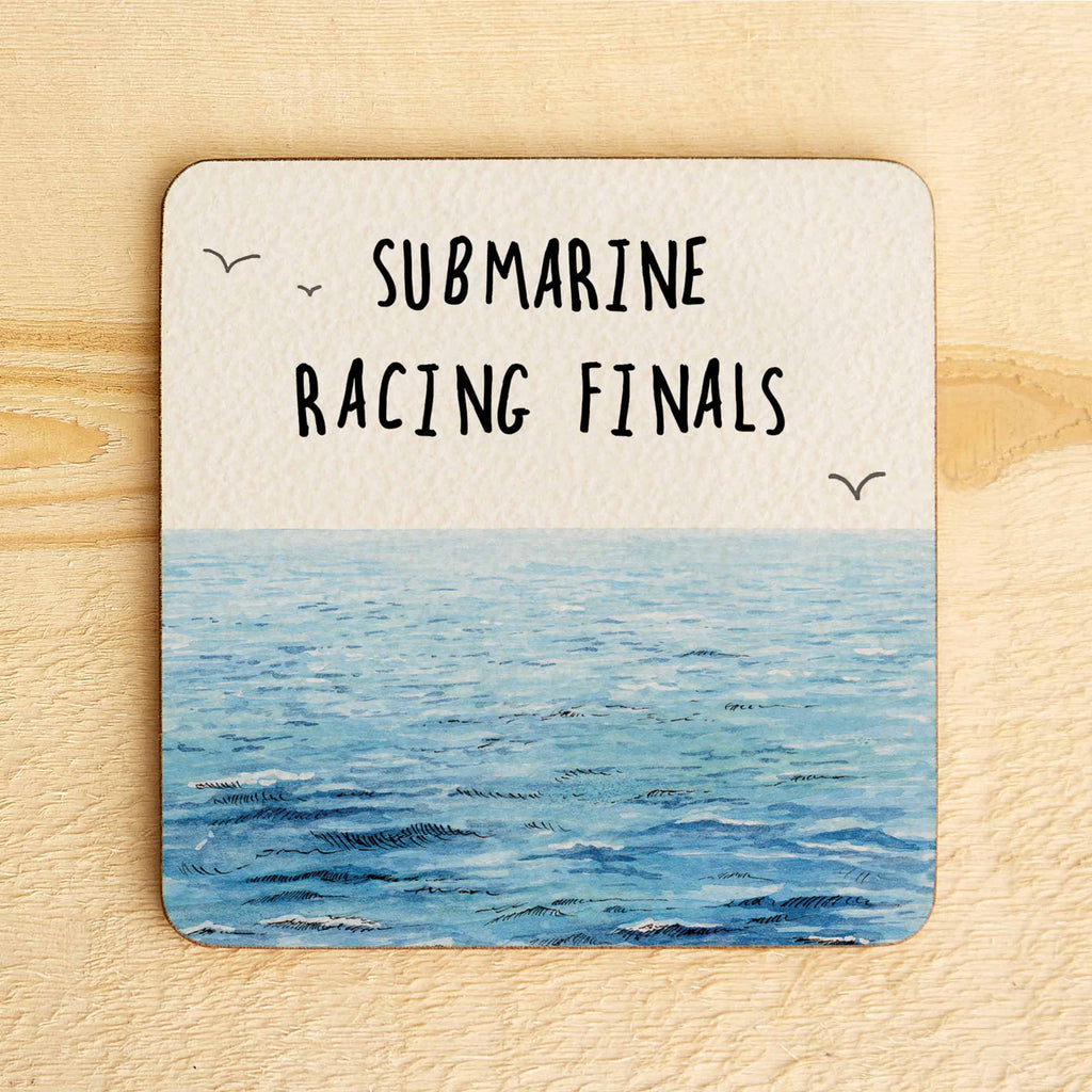 Coaster with ocean design and text 'SUBMARINE RACING FINALS' on a wooden surface
