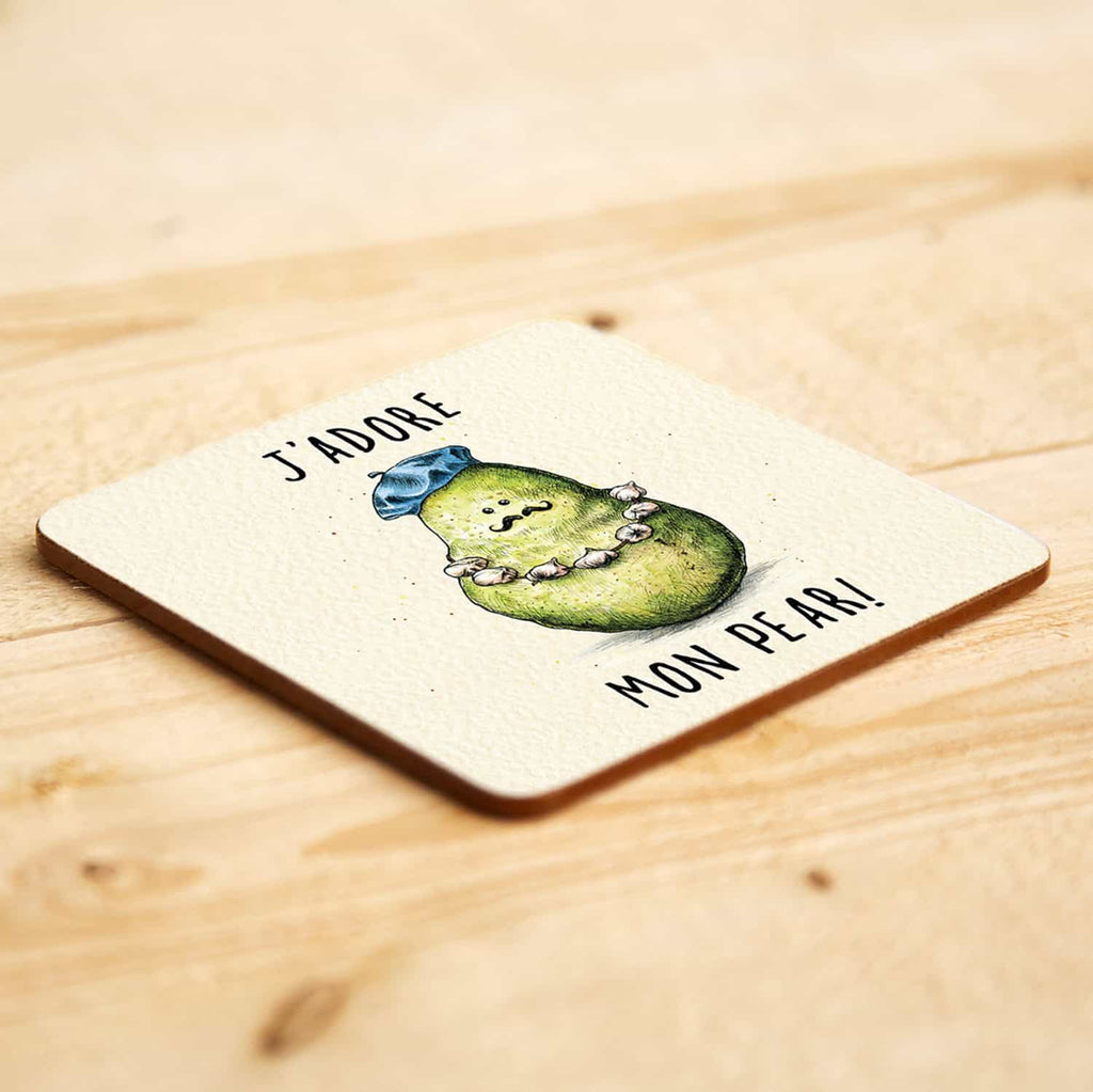 Coaster with a pear illustration and text saying "J'adore Mon Pear" on a wooden surface