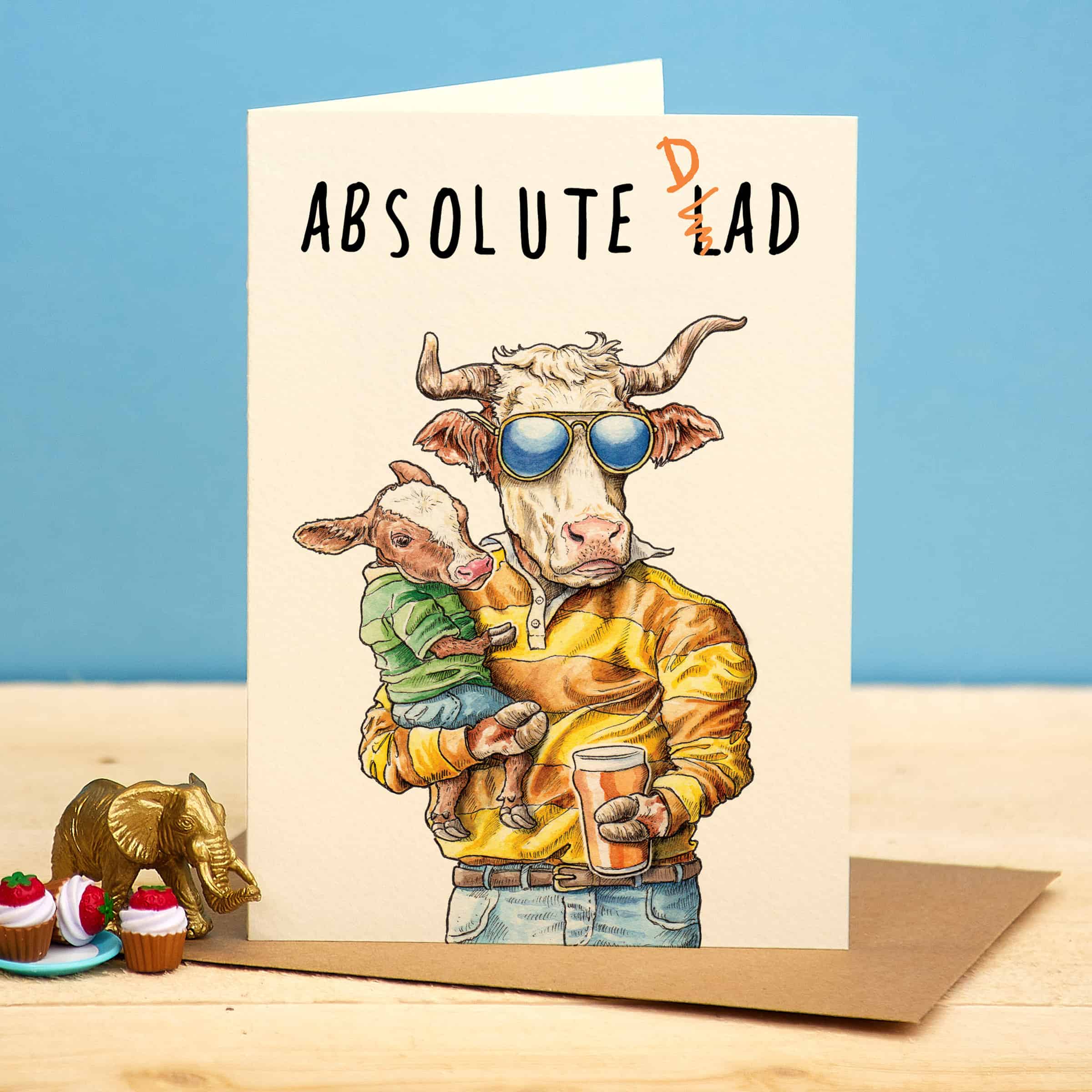 Card with illustration of a cow holding a calf and text 'Absolute Dad' on a blue background