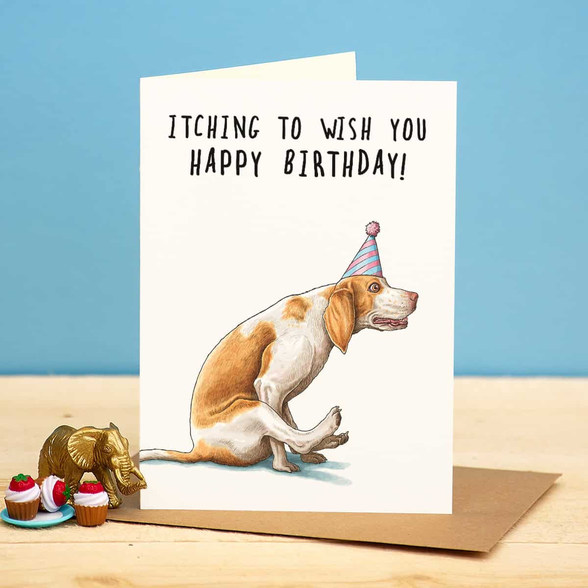 Birthday card with a dog wearing a party hat and text 'Itching to wish you happy birthday!' on a blue background.