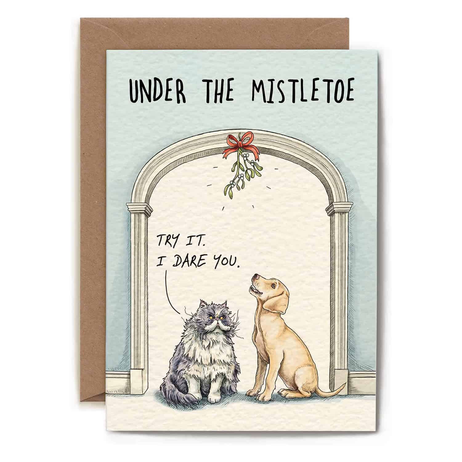 Greeting card with two dogs under a mistletoe archway and humorous text.