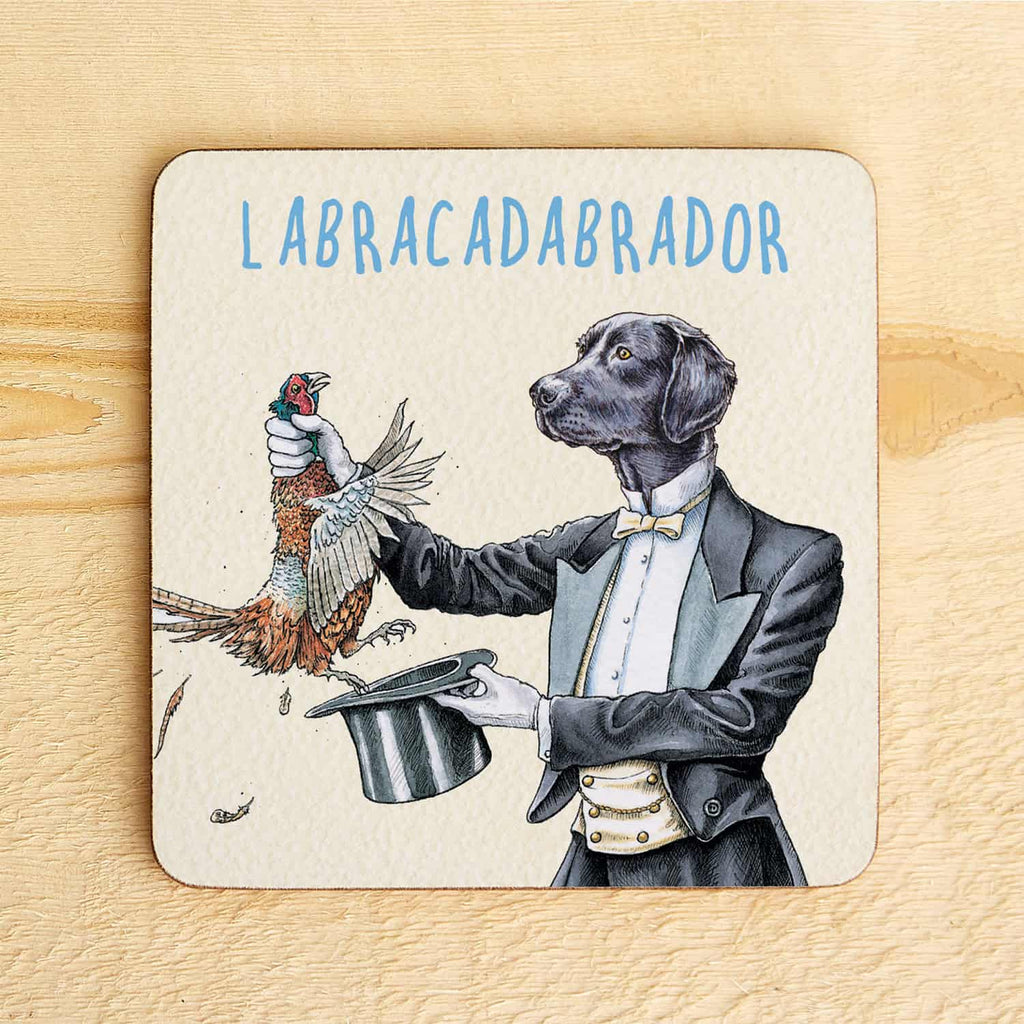Coaster with a magician labrador dog in a tuxedo holding a bird and a top hat, labeled 'LABRACADABRADOR'.