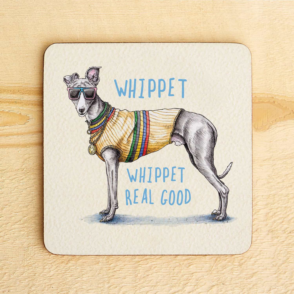 Coaster with a drawing of a whippet wearing sunglasses and a sweater, text 'WHIPPET WHIPPET REAL GOOD' on a wooden surface.