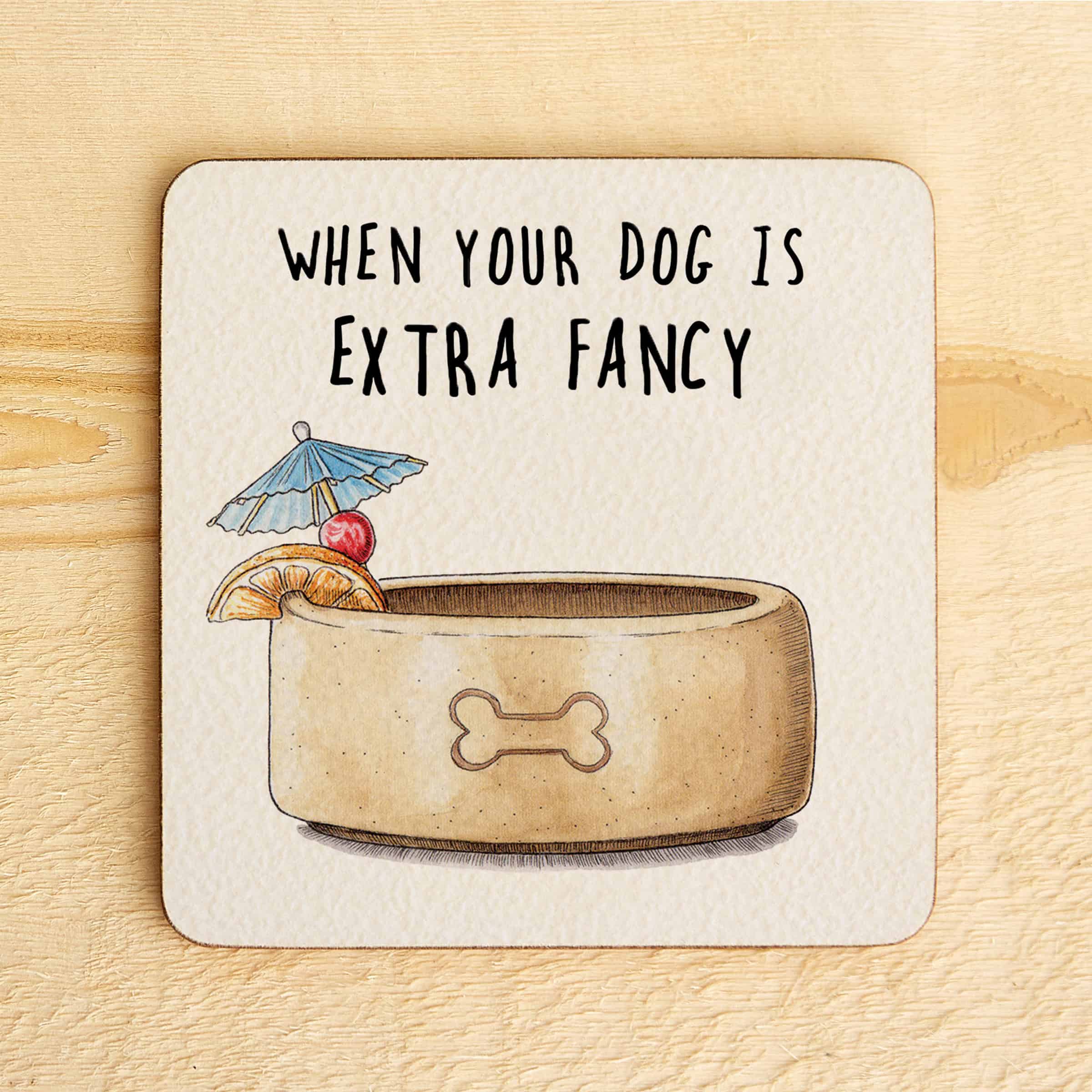Coaster with a dog bowl illustration and text 'When your dog is extra fancy' on a wooden surface.