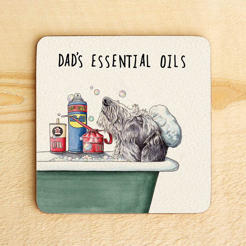 Coaster with a dog taking a bath and 'Dad's Essential Oils' text on a wooden surface
