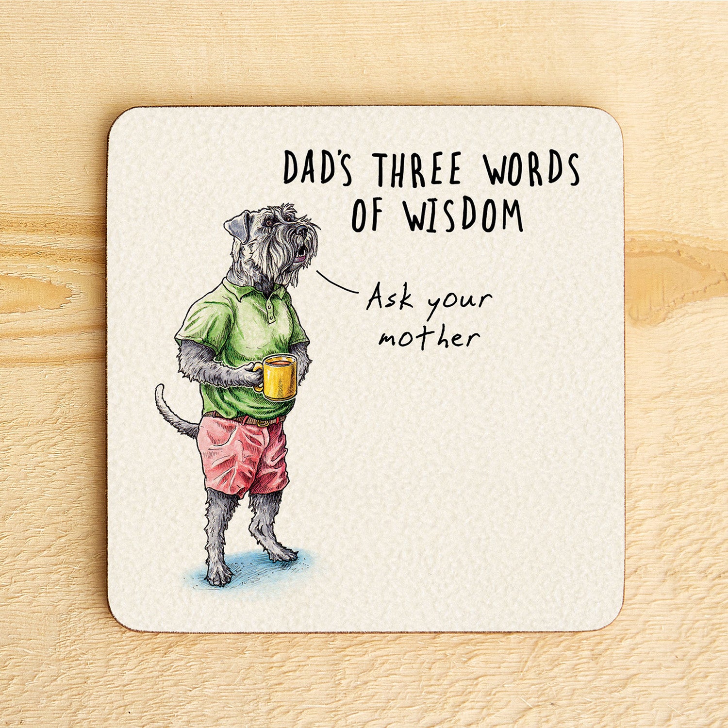 Coaster with a dog illustration and humorous text on a wooden surface