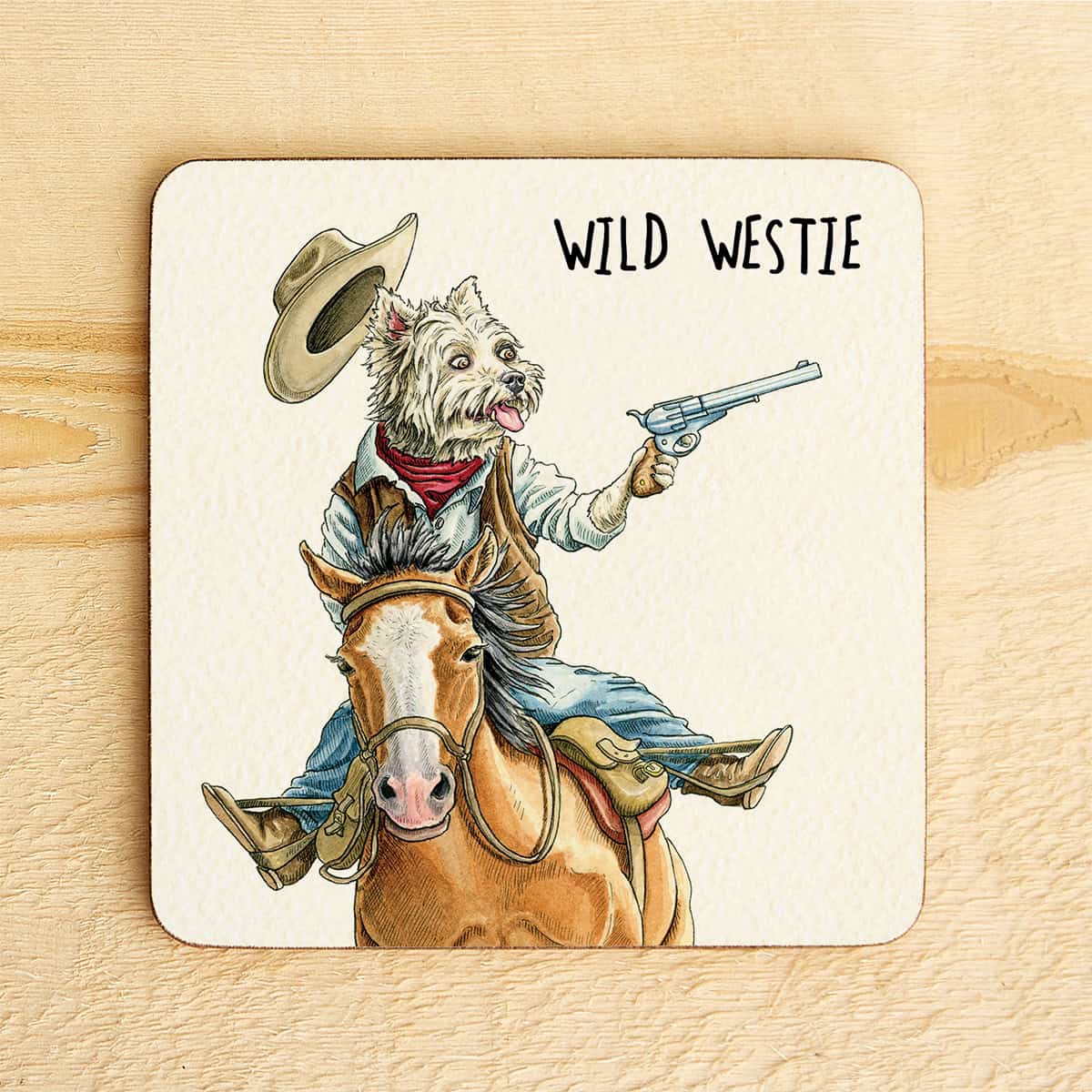 Coaster with illustration of a Westie dog on horseback holding a gun, labeled 'Wild Westie', on a wooden surface.