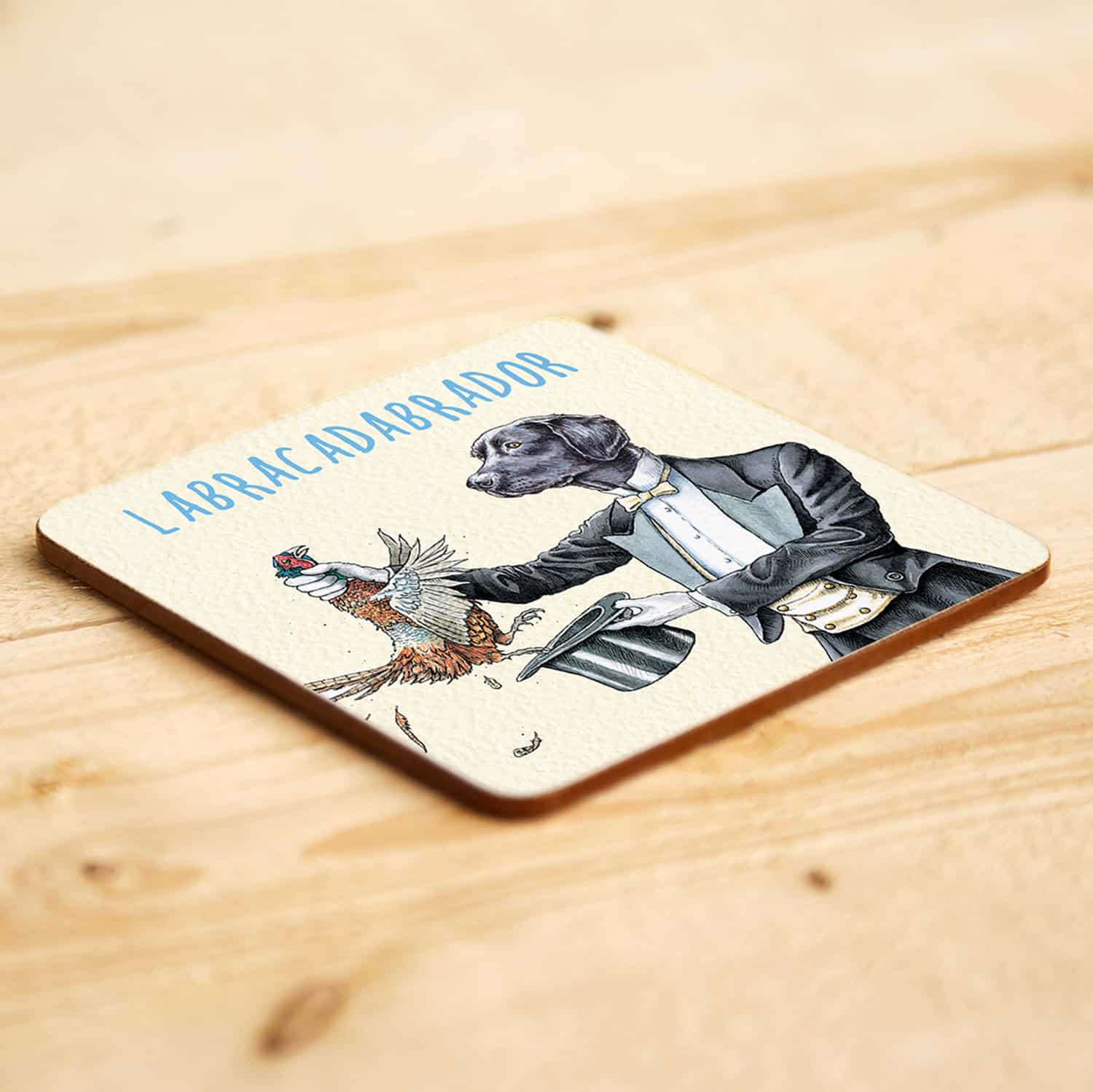 Coaster with a magician labrador dog in a tuxedo holding a bird and a top hat, labeled 'LABRACADABRADOR'.