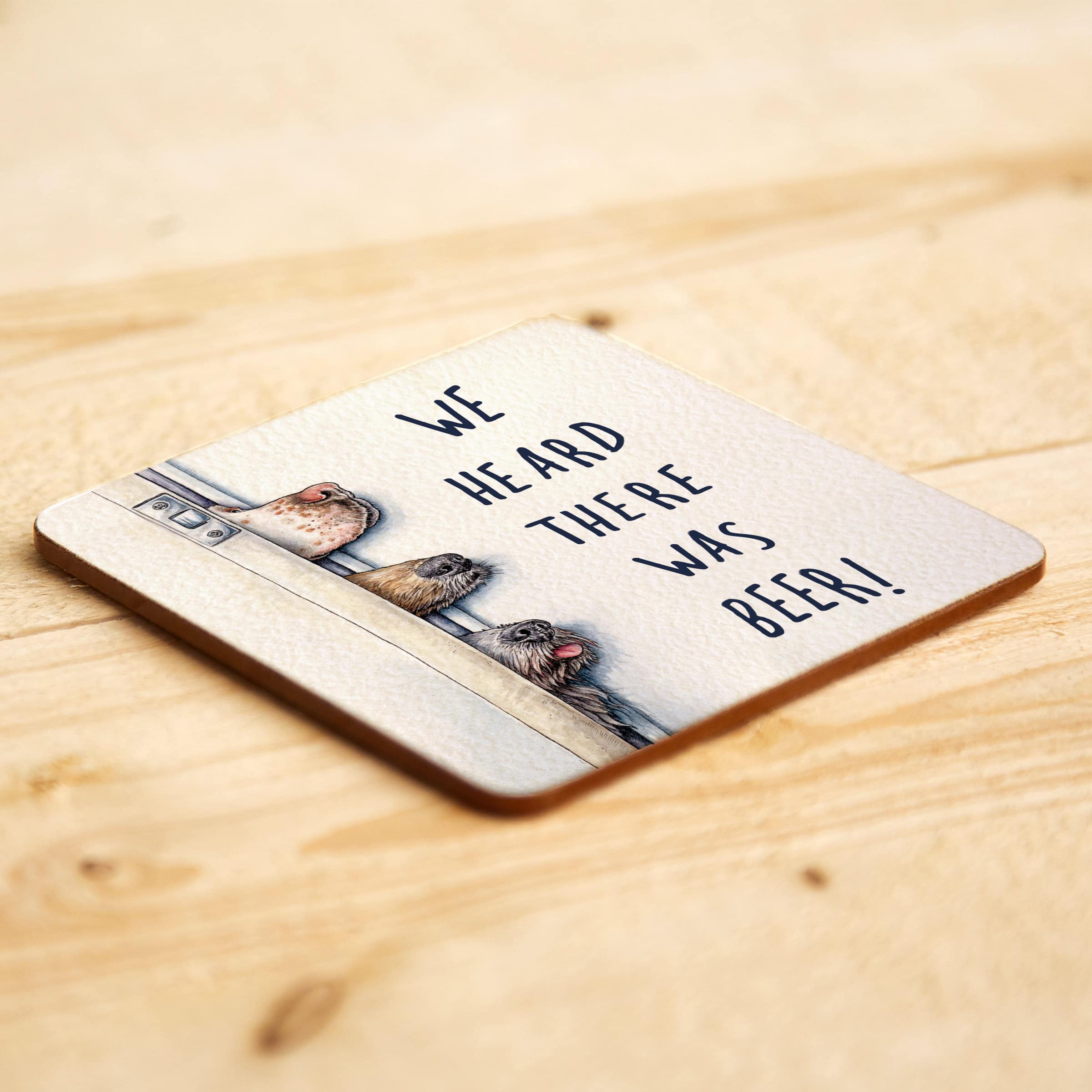 Coaster with dogs and text 'We heard there was beer!' on a wooden surface