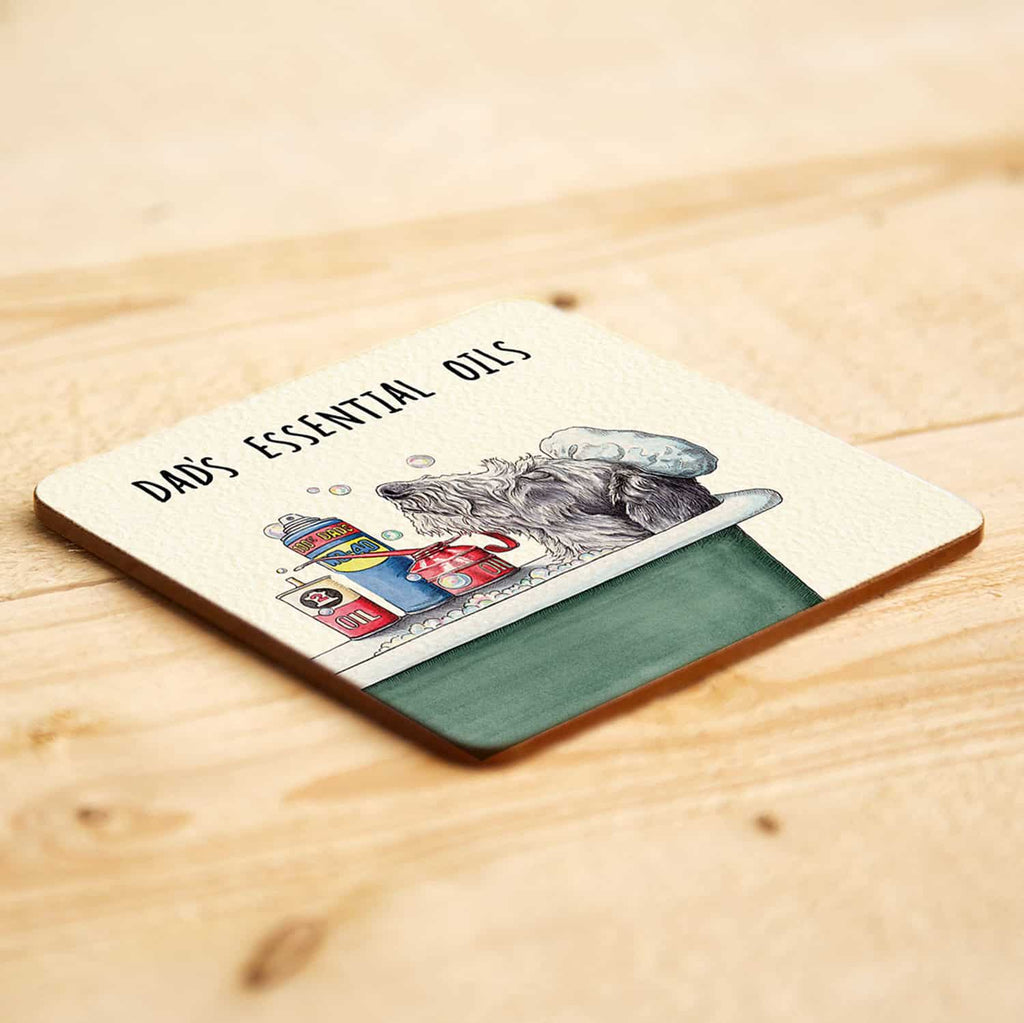 Coaster with a design of a dog and text 'Dad's Essential Oils' on a wooden surface