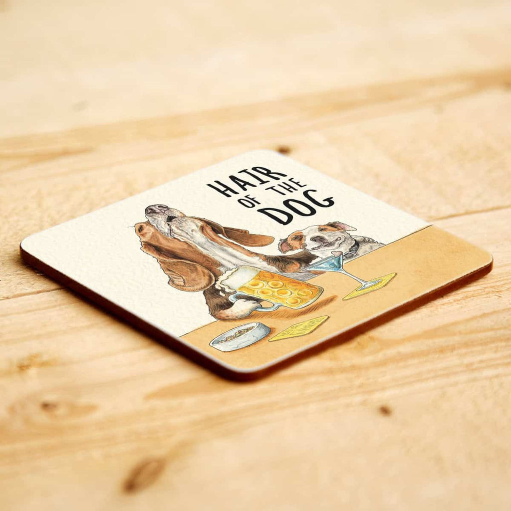 Coaster with a dog illustration and 'Hair of the Dog' text on a wooden surface