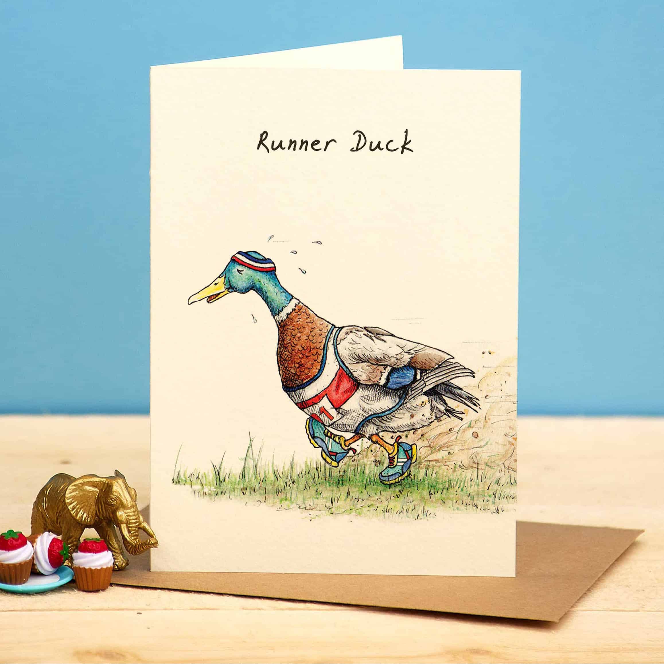 Greeting card with a runner duck illustration on a wooden surface with a blue background