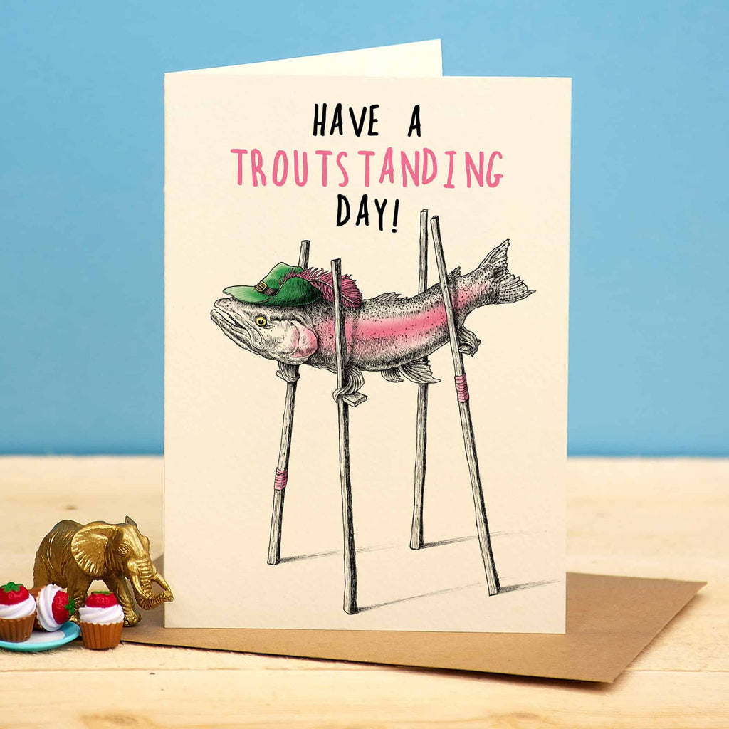Greeting card with a fish illustration and text 'Have a troutsstanding day!' on a blue background.