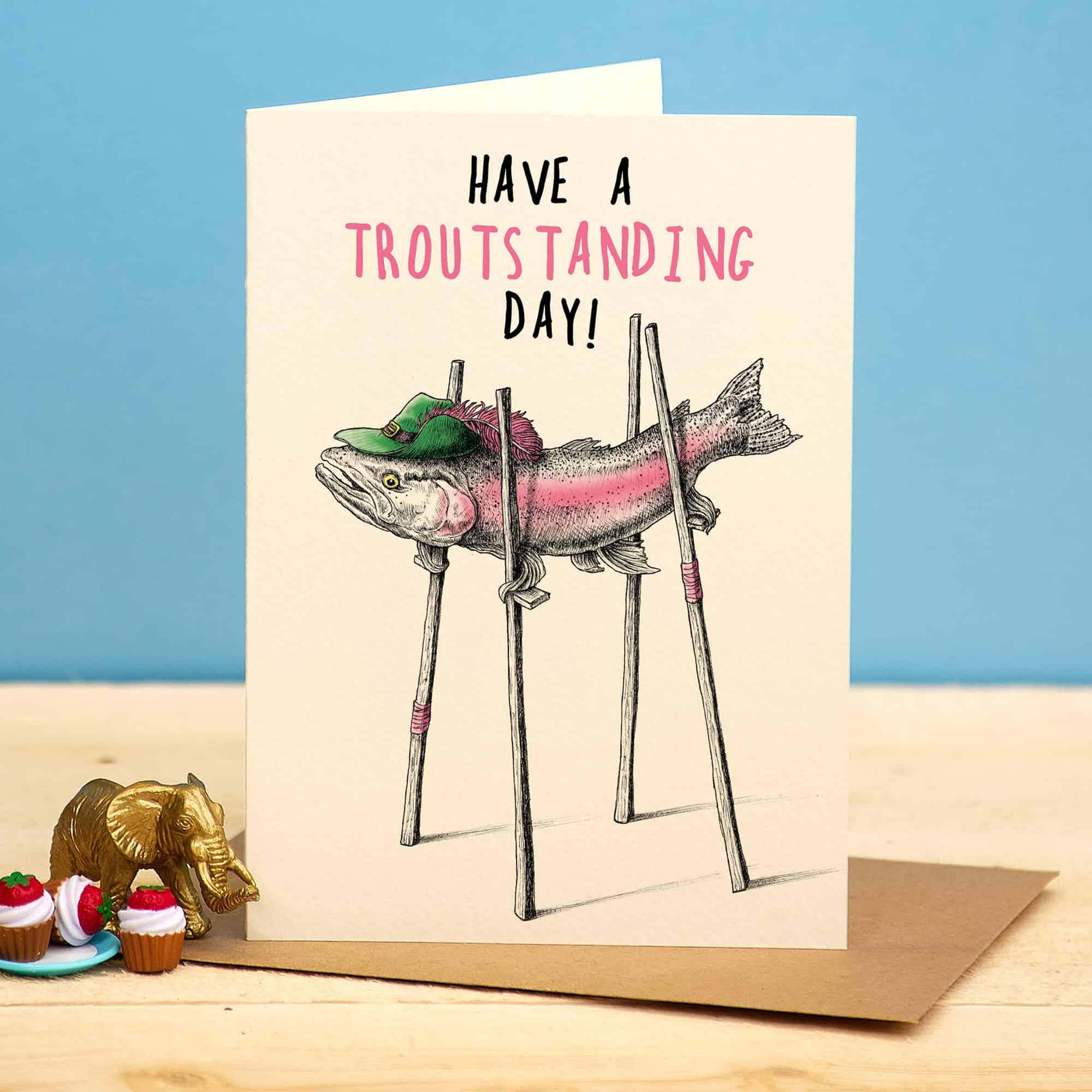 Greeting card with a fish illustration and text 'Have a troutsstanding day!' on a blue background.