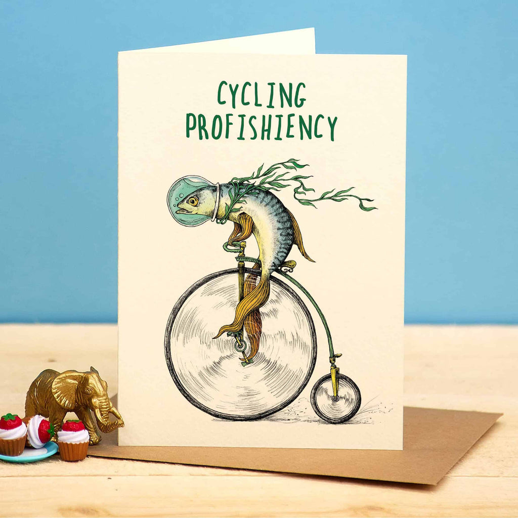 Card with a fish riding a penny-farthing bicycle and text 'Cycling Profishiency' on a blue background.