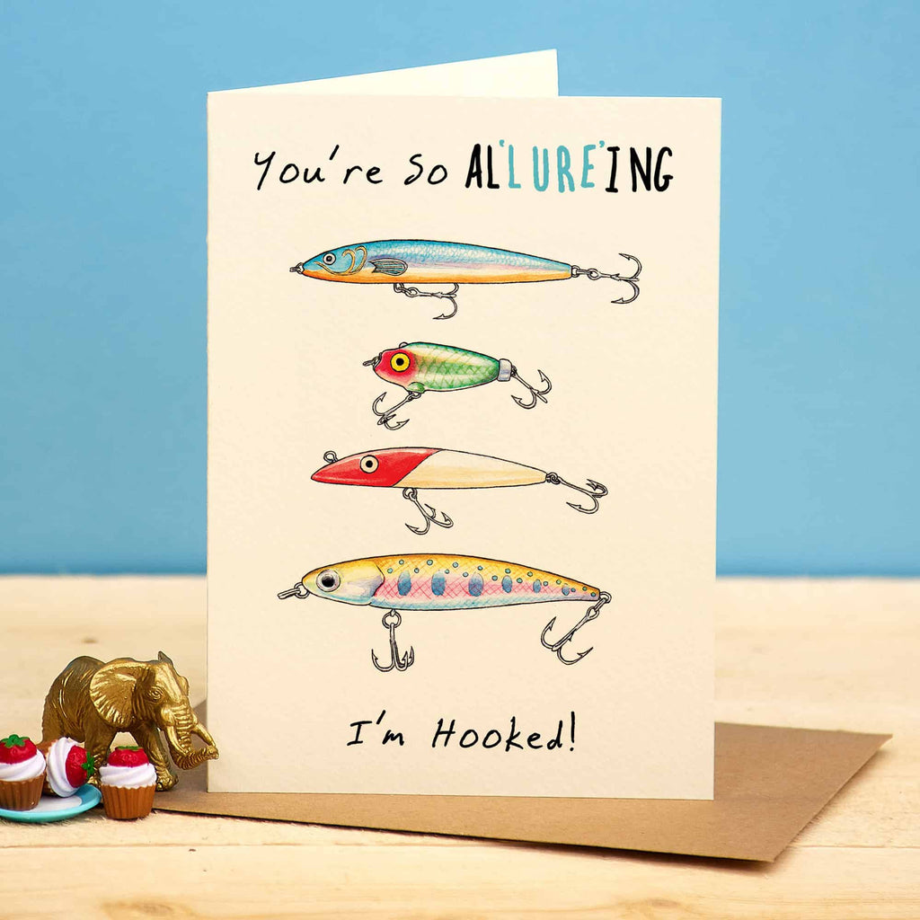 Card with fishing lures and text 'You're So Allure'ing, I'm Hooked!' on a blue background
