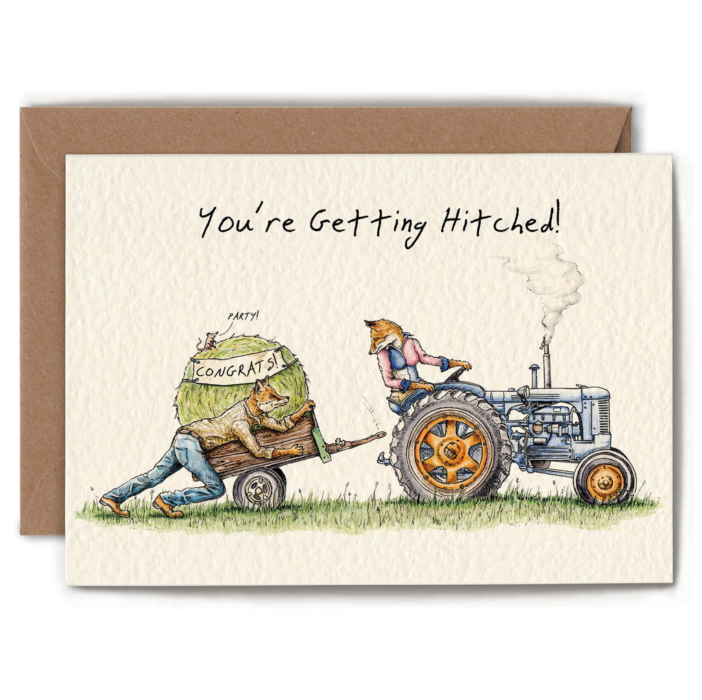 Card with illustration of a tractor and  cart, with two foxes, with text 'You're Getting Hitched!'.