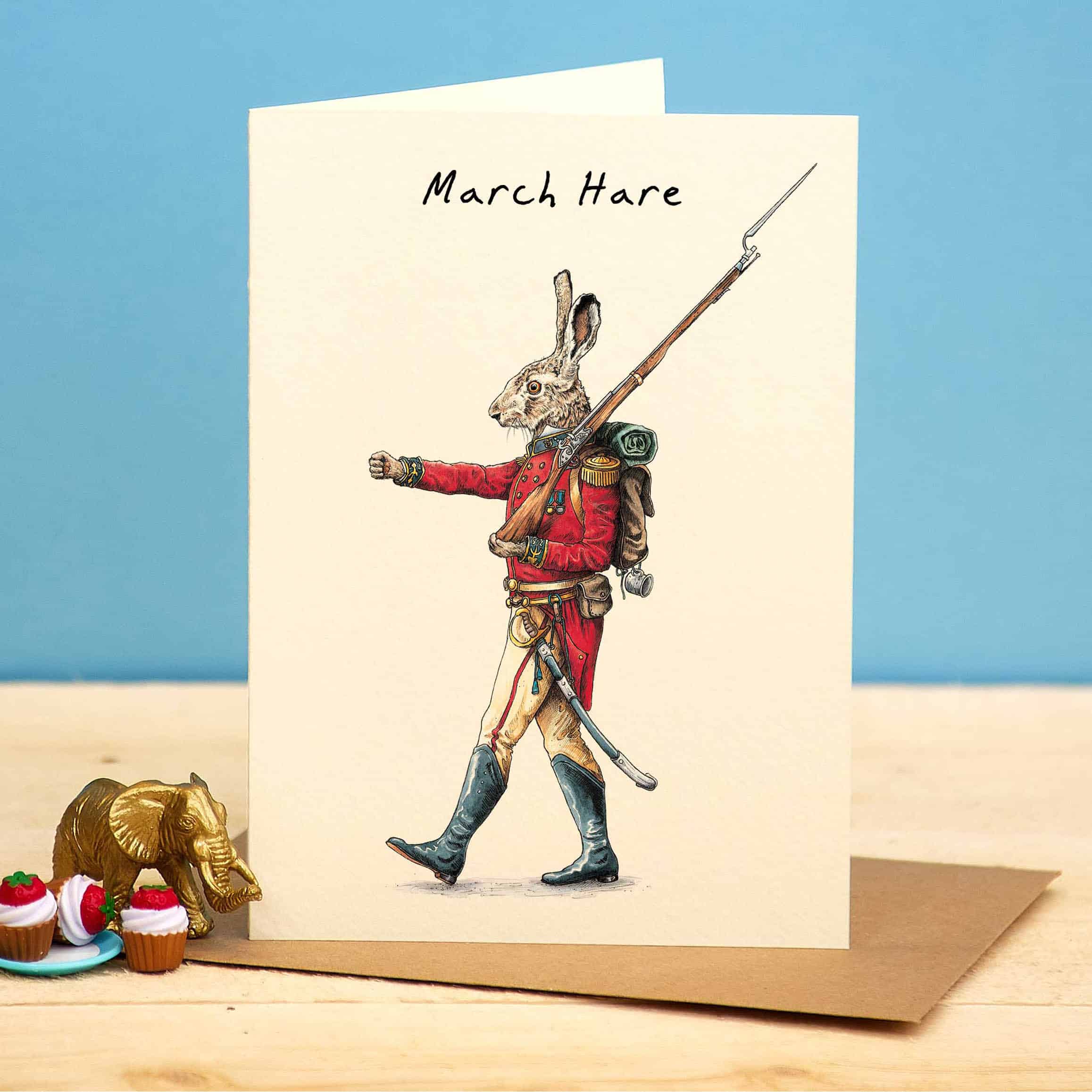 Card with a hare illustration in a red coat and hat, holding a spear, on a beige background.