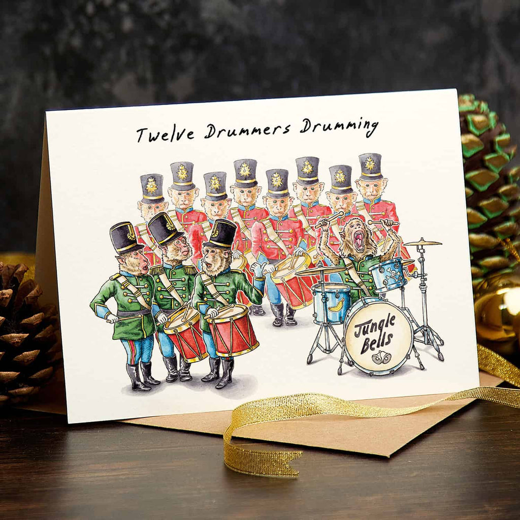 Christmas card with illustration of twelve drummers drumming, surrounded by festive decorations.