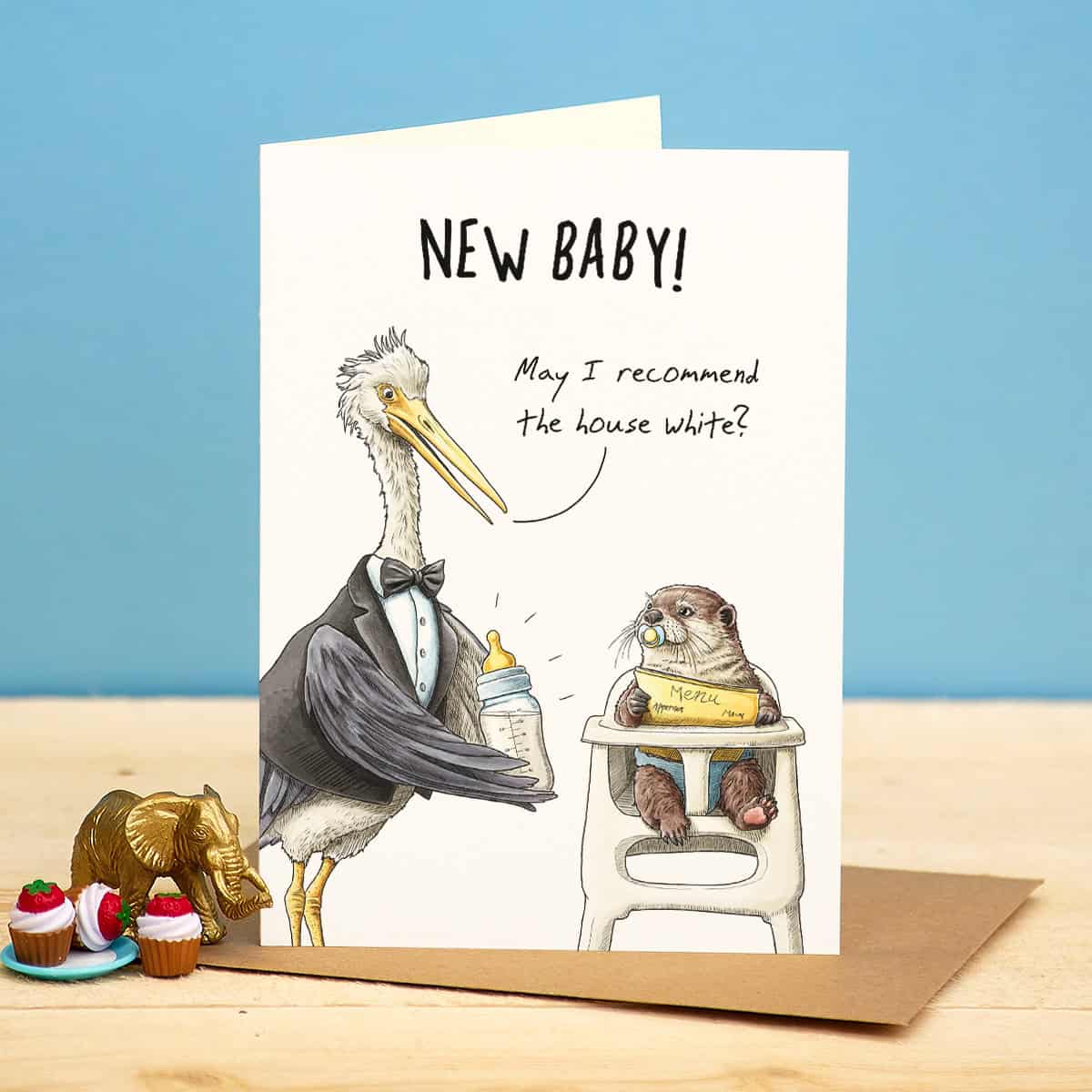 Greeting card with illustrations of a pelican and an otter, featuring text 'New Baby! May I recommend the house white?' on a blue background.