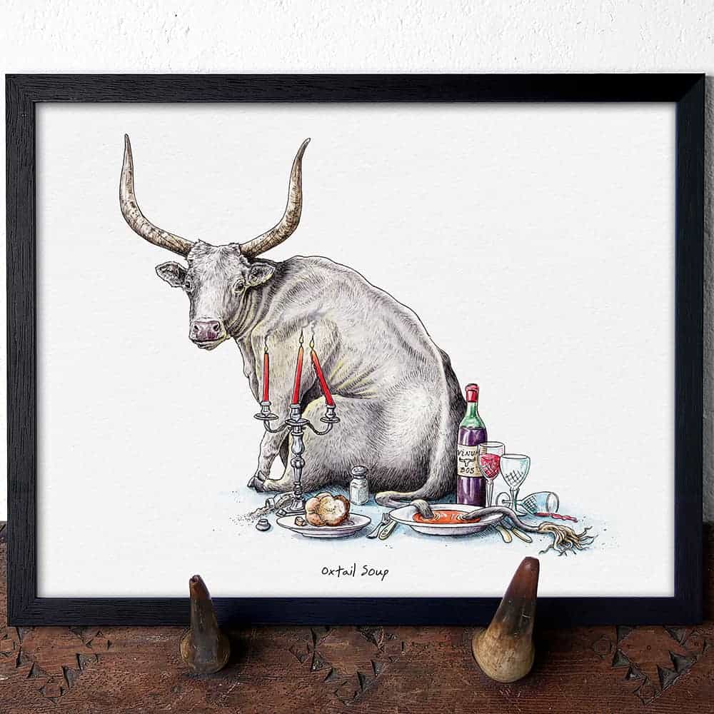 Framed artwork of a longhorn cow with a table setting on a white background