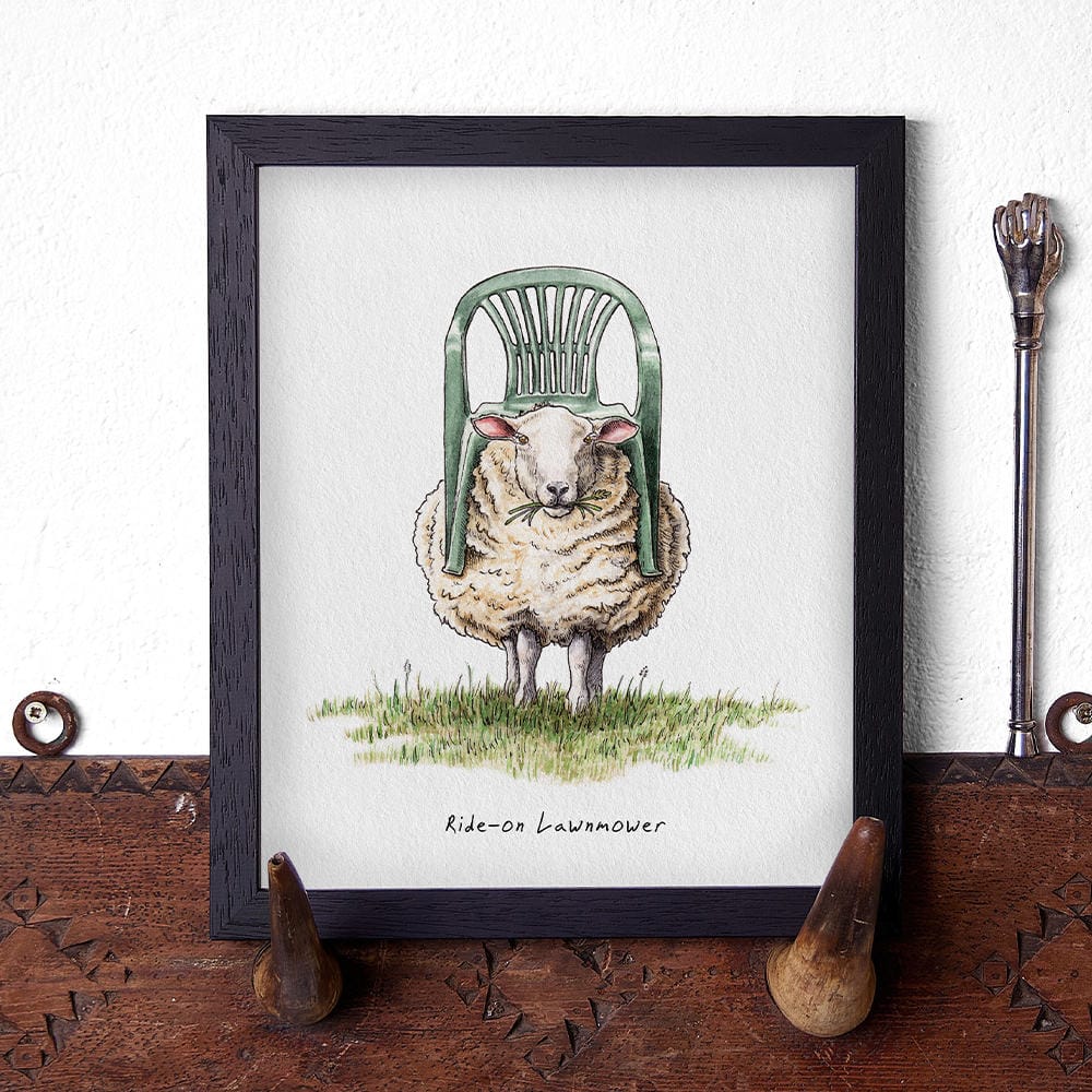 Artwork of a sheep with a lawnmower on its back, displayed on a wooden surface.