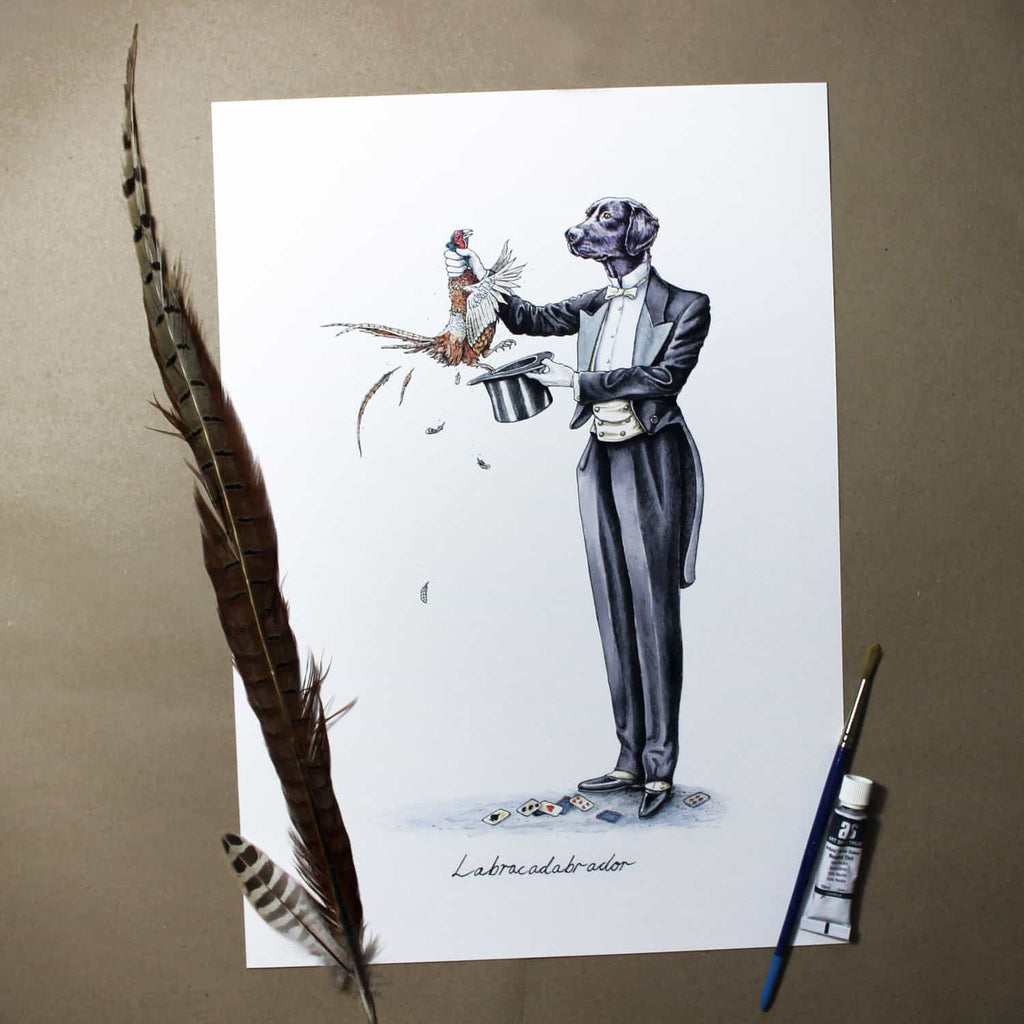 Painting of a black Labrador wearing a suit pulling a pheasant from a hat on white paper next to a feather