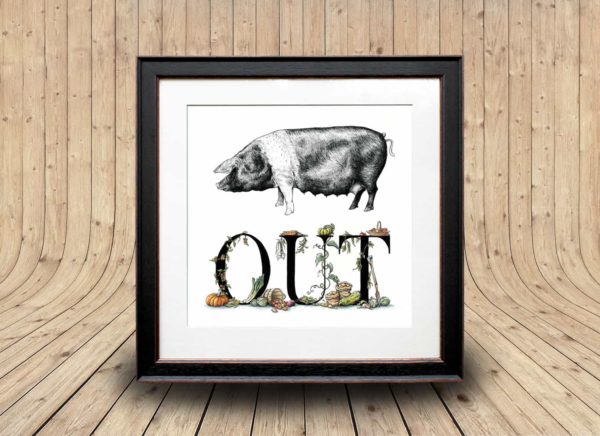Print of a saddleback pig and lettering decorated with vegetables in a black frame on a wooden background