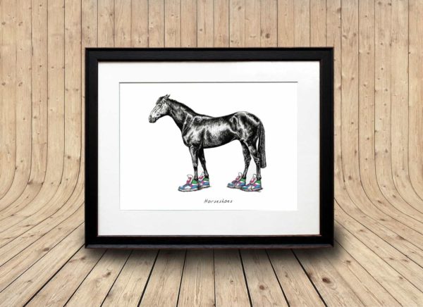 Print of a horse drawn with pen and ink wearing bright coloured trainers in a black frame on a wooden curved background