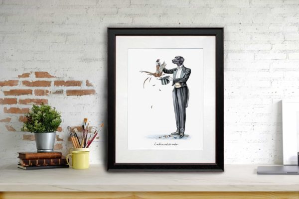 Print of a black Labrador in a magician’s outfit pulling a pheasant out a hat in a black frame leaning against a brick wall